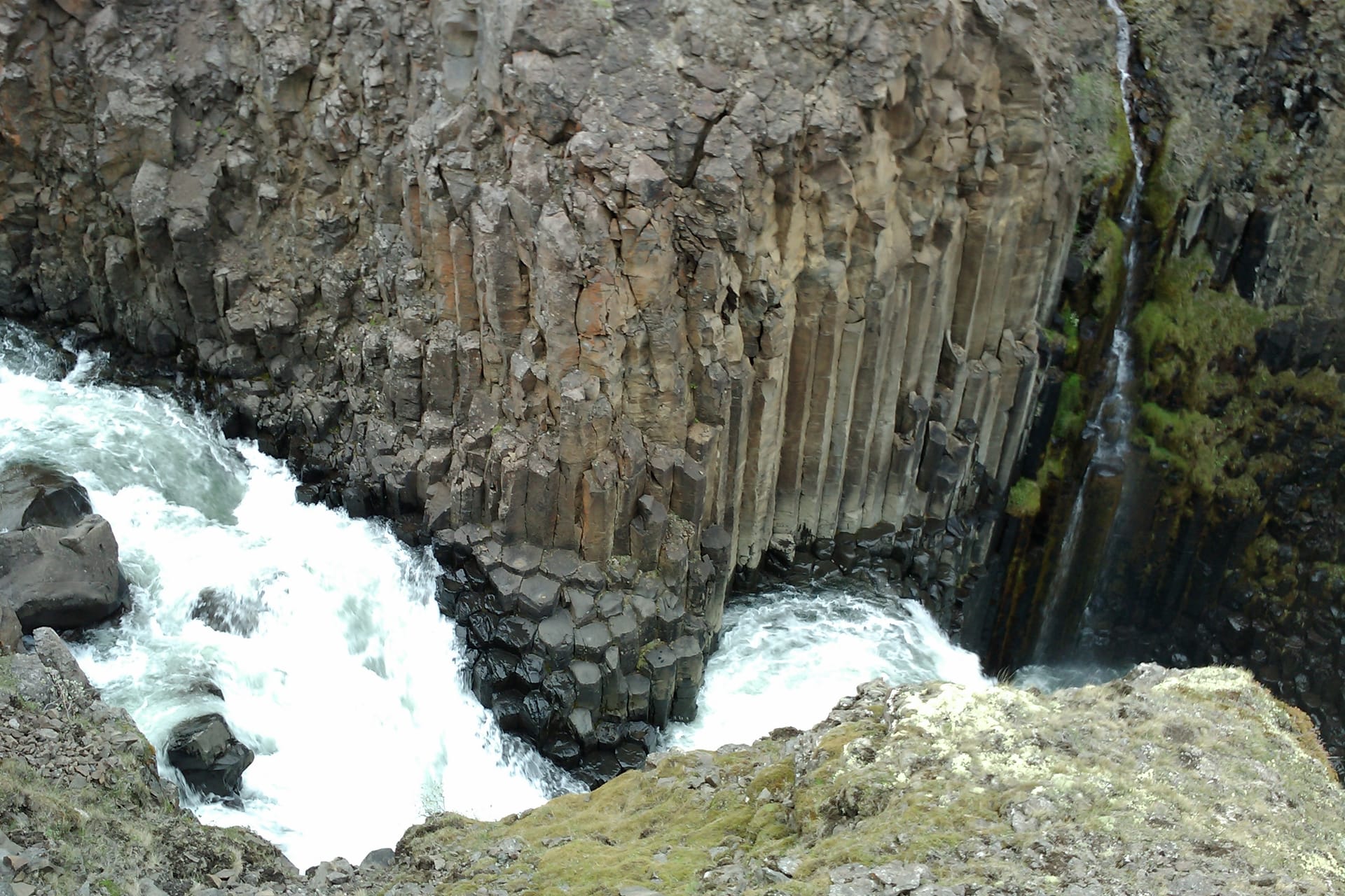 Litlanesfoss waterfall framed by tall basalt columns in East Iceland