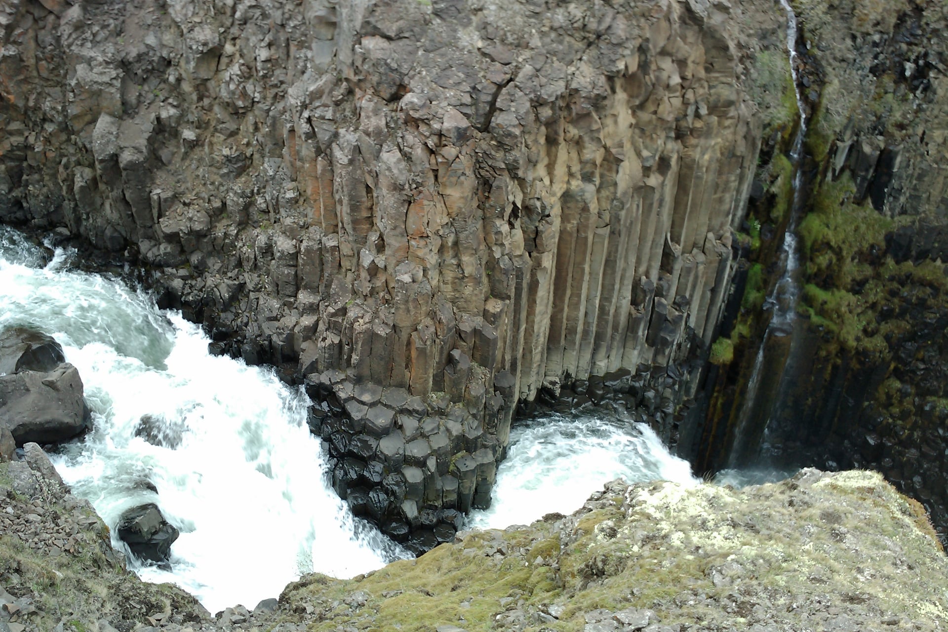 Litlanesfoss waterfall framed by tall basalt columns in East Iceland